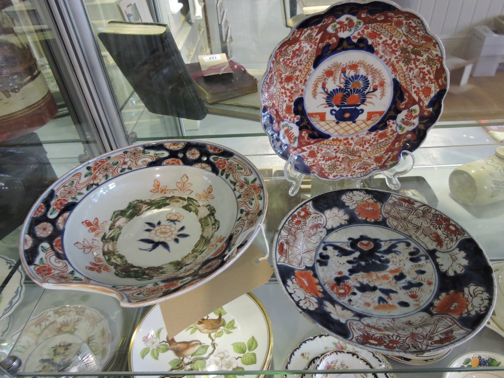 An Imari pattern bleeding bowl, D. 26cm; together with two other Imari dishes. (3)