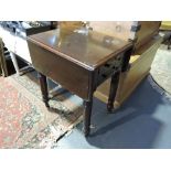 A Victorian mahogany two drawer work table with twin flap top on turned tapered legs.