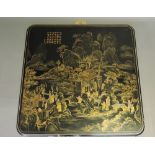 A Chinese 20th century black lacquer square panel, showing figures in a temple in a mountainous