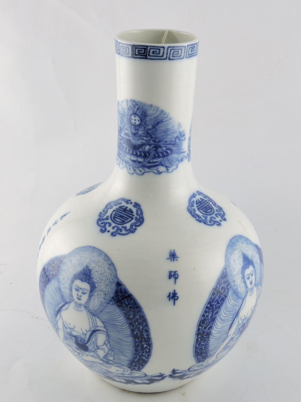 A blue and white Chinese vase, decorated with images of Buddha and characters, the base with a