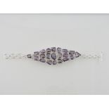 A silver and amethyst bracelet, set with 20 irregular stones with bar clasp.