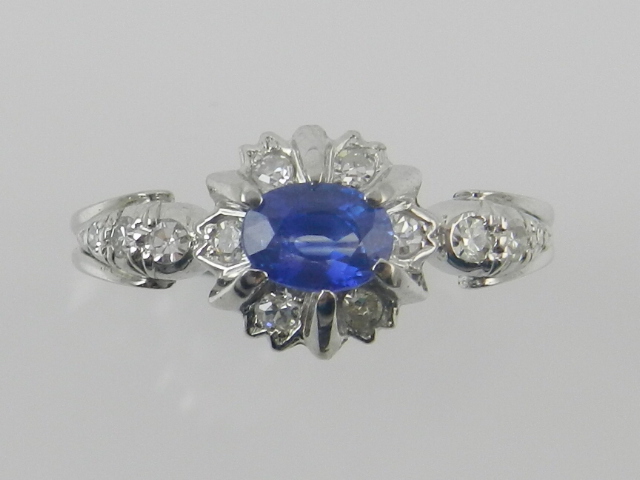 A white metal, diamond and sapphire clus