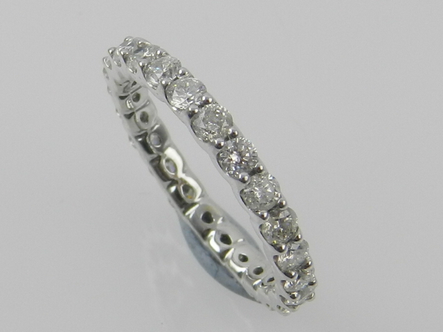 A white metal and diamond eternity ring,