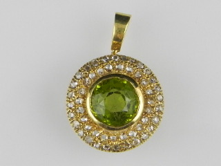 A yellow metal pendant, centred with a peridot within diamond surround.