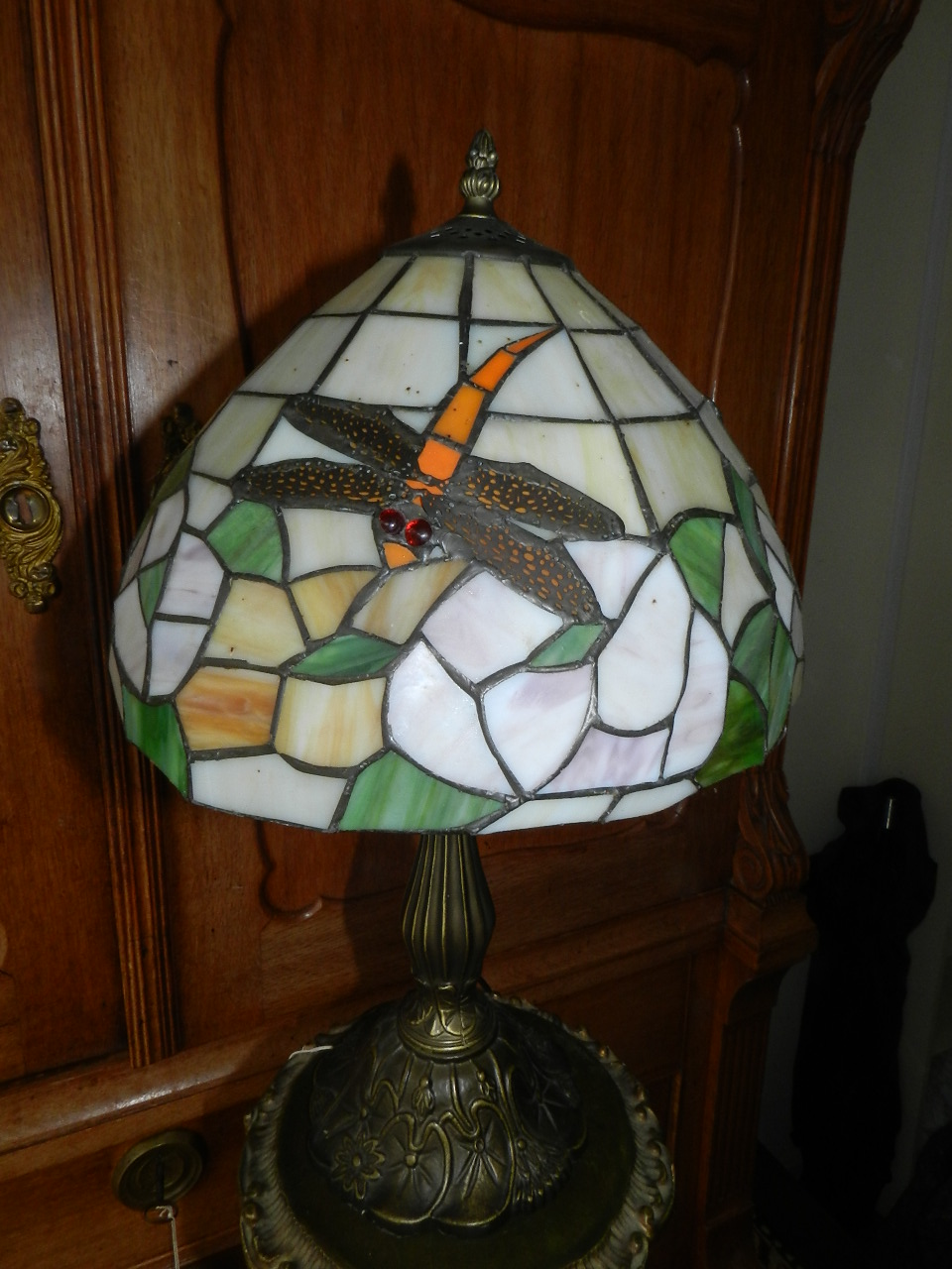 A Tiffany style table lamp base, having leaded glass shade decorated with dragonflies.
