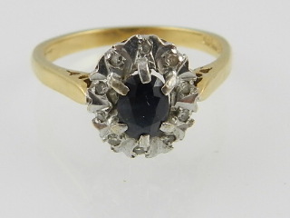 An 18 carat yellow gold, sapphire, and diamond cluster ring.