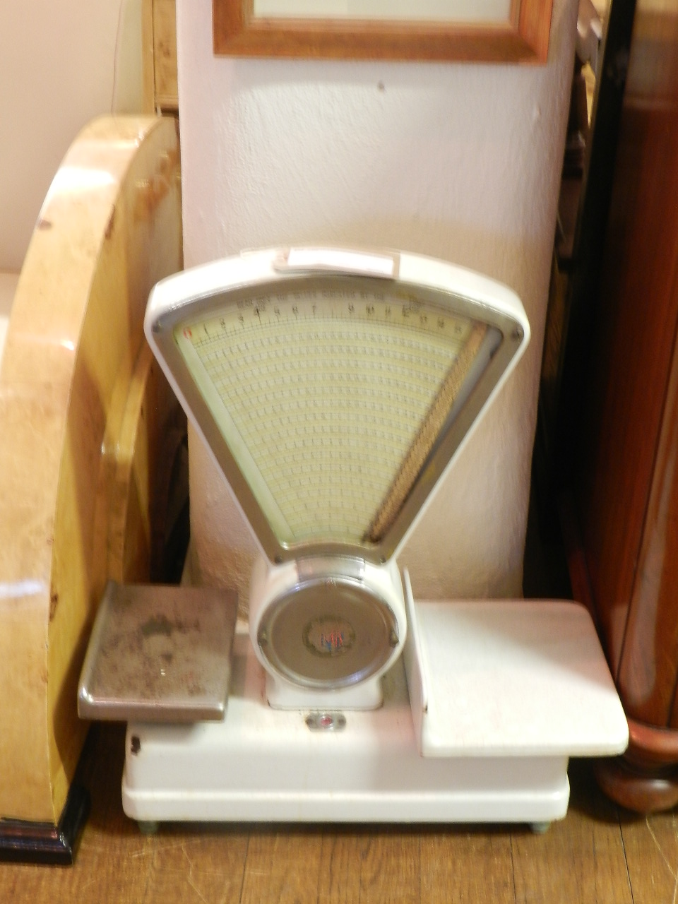 A large set of white enamel and chrome grocery scales.