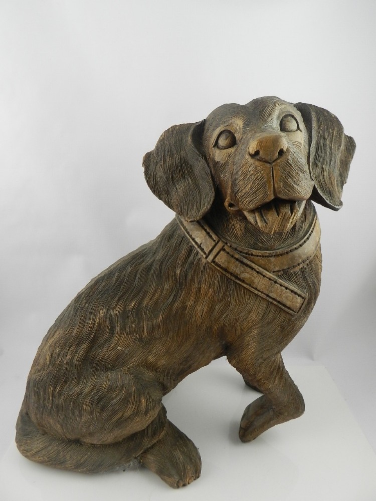 A late 19th/early 20th century Black Forest carved beech wood study of a seated puppy, H. 38 cm.