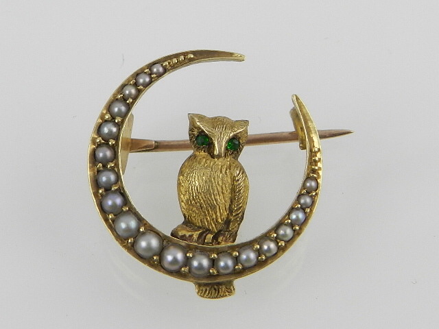 A late 19th / early 20th century yellow metal crescent pin brooch, set with split seed pearls,