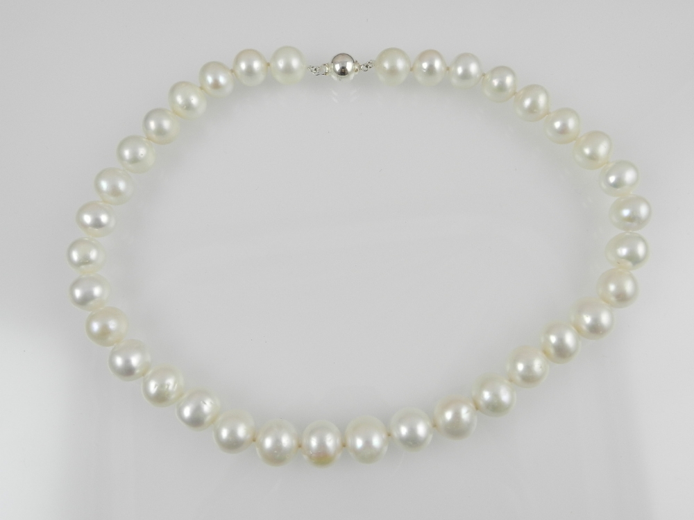 A single strand cultured pearl necklace with spherical white metal clasp.