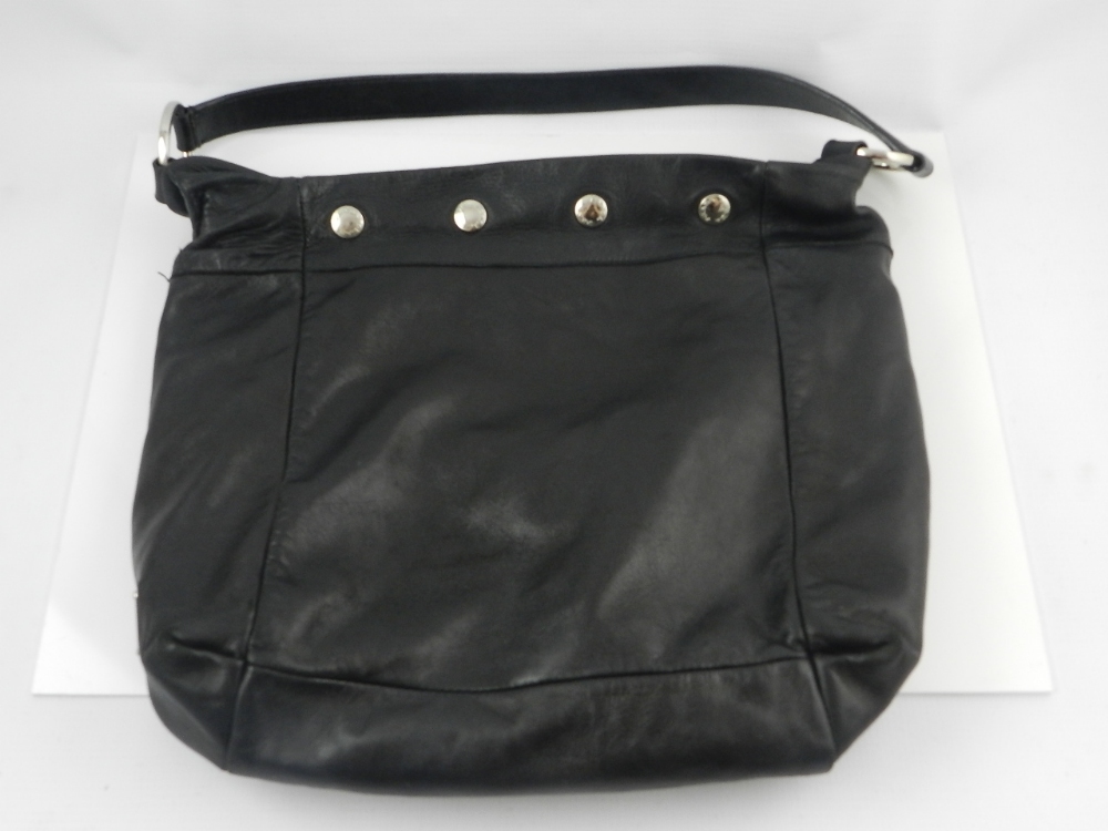 Prada, Milan. A black leather shoulder bag with white metal stud detail.