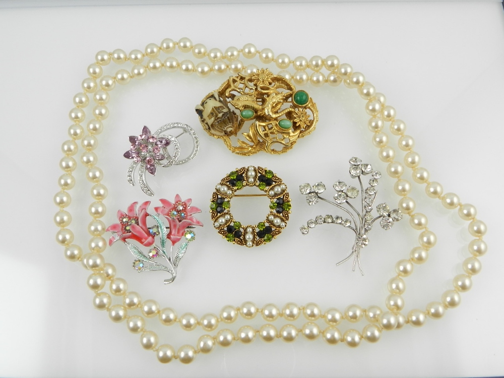 A collection of five costume jewellery brooches, together with a simulated pearl opera length