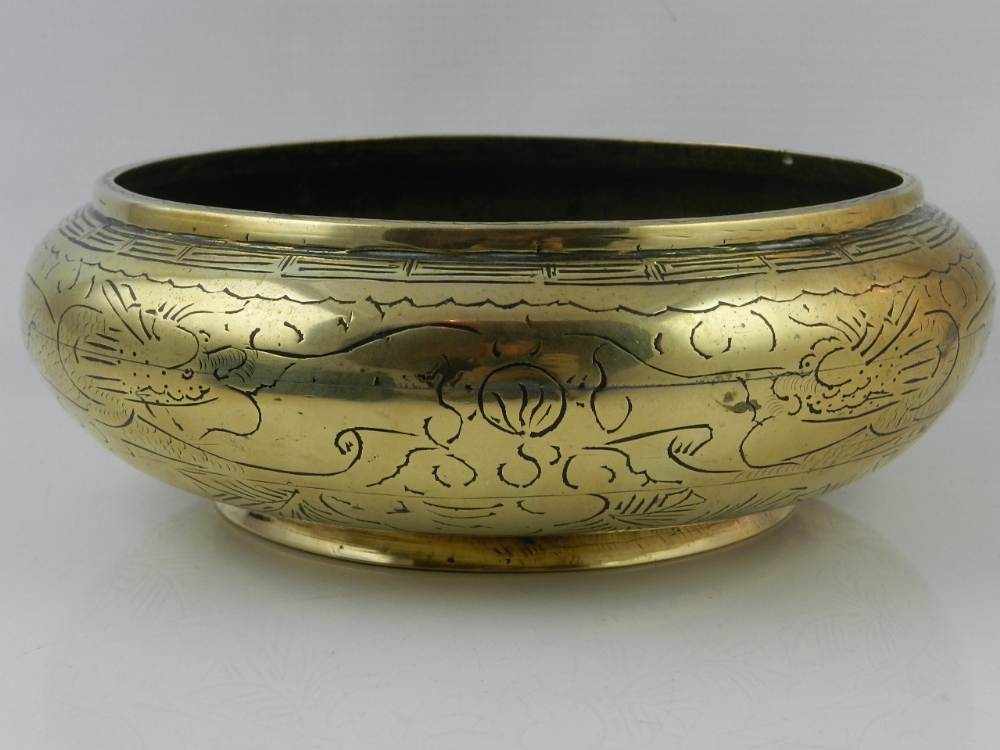 A Chinese bronze bowl, etching with a twin dragon frieze, bearing raised six character marks to