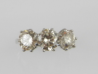 A fine white metal three stone diamond ring, the brilliant cut stones of approx. 3.26cts combined,