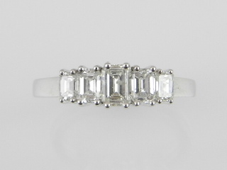 A white metal five stone diamond ring in the Art Deco style, set five graduated emerald cut diamonds