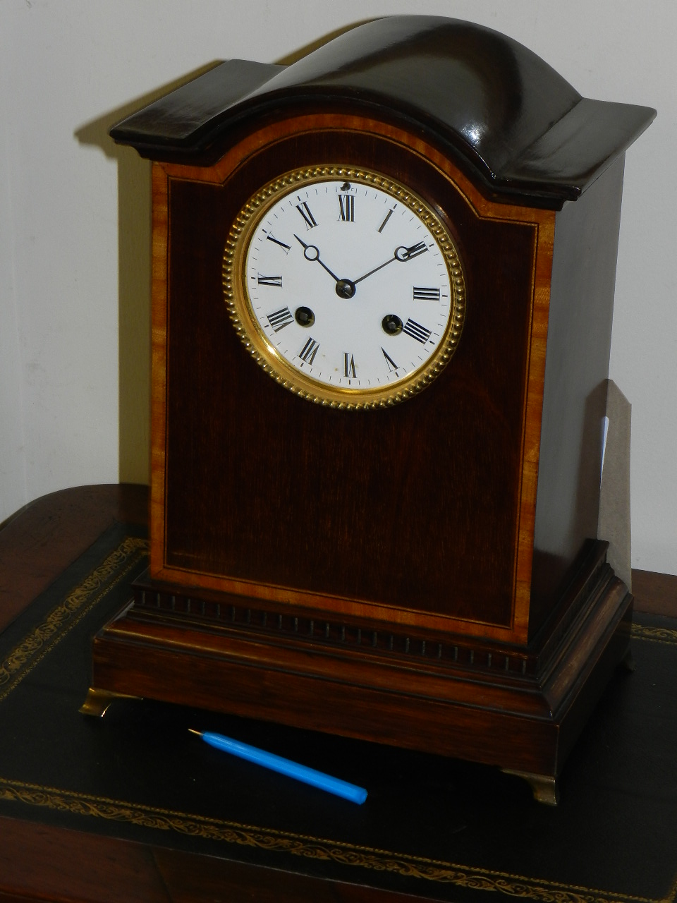 An Edwardian mahogany cased mantel clock, the rectangular case with arched hood and satinwood