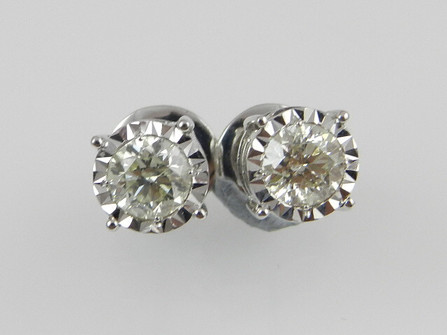 A pair of white metal diamond ear studs with screw backs, with illusion set brilliant cut stones