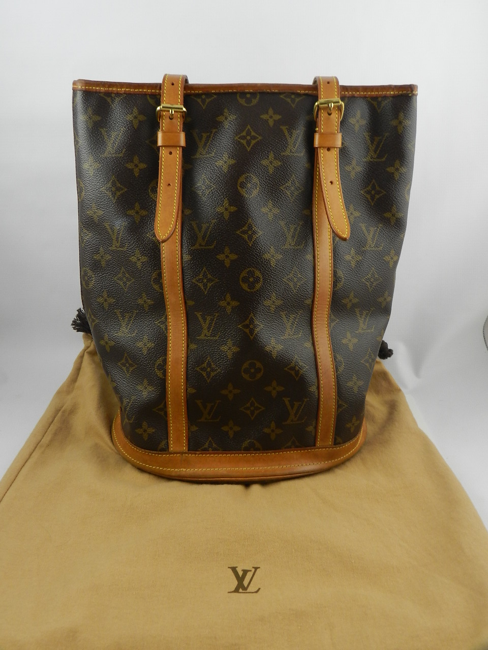 Louis Vuitton, Paris. A brown leather monogram bucket bag with tan leather shoulder straps,