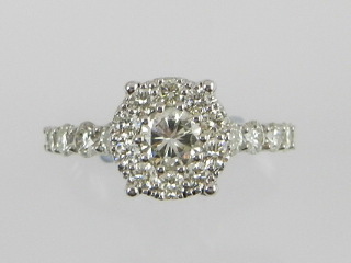 An unusual white metal diamond cluster ring centred with a brilliant cut diamond with diamond