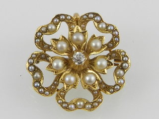 A late Victorian/Edwardian yellow gold split seed pearl and diamond set flower head brooch.