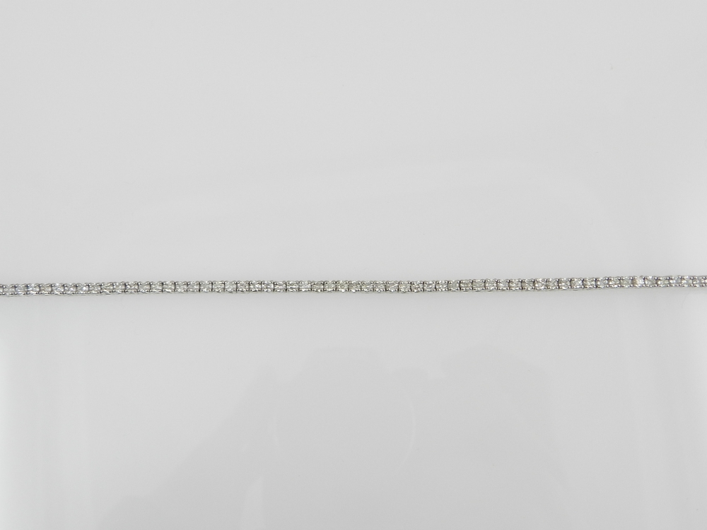 A white metal diamond line bracelet, set brilliant cut stones of approx. 3.72cts combined, the clasp