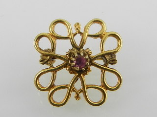 A yellow metal pin brooch centred with a ruby, stamped 9ct to verso.