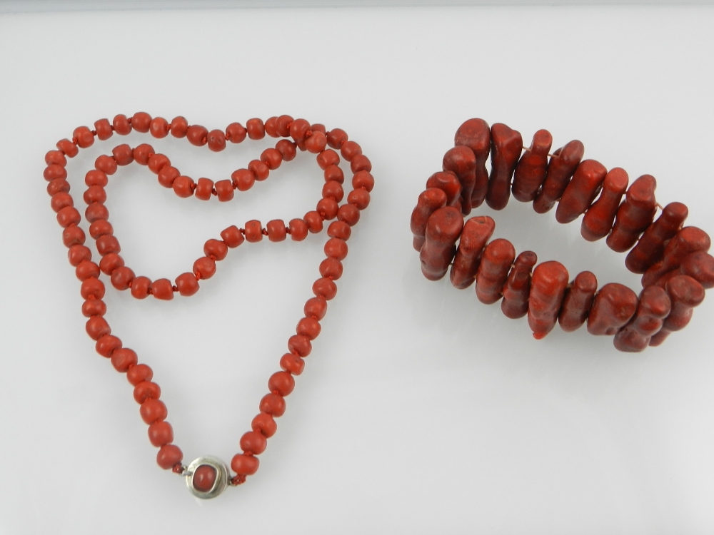 A red stained coral beaded necklace with white metal clasp, set coral cabochon, together with a