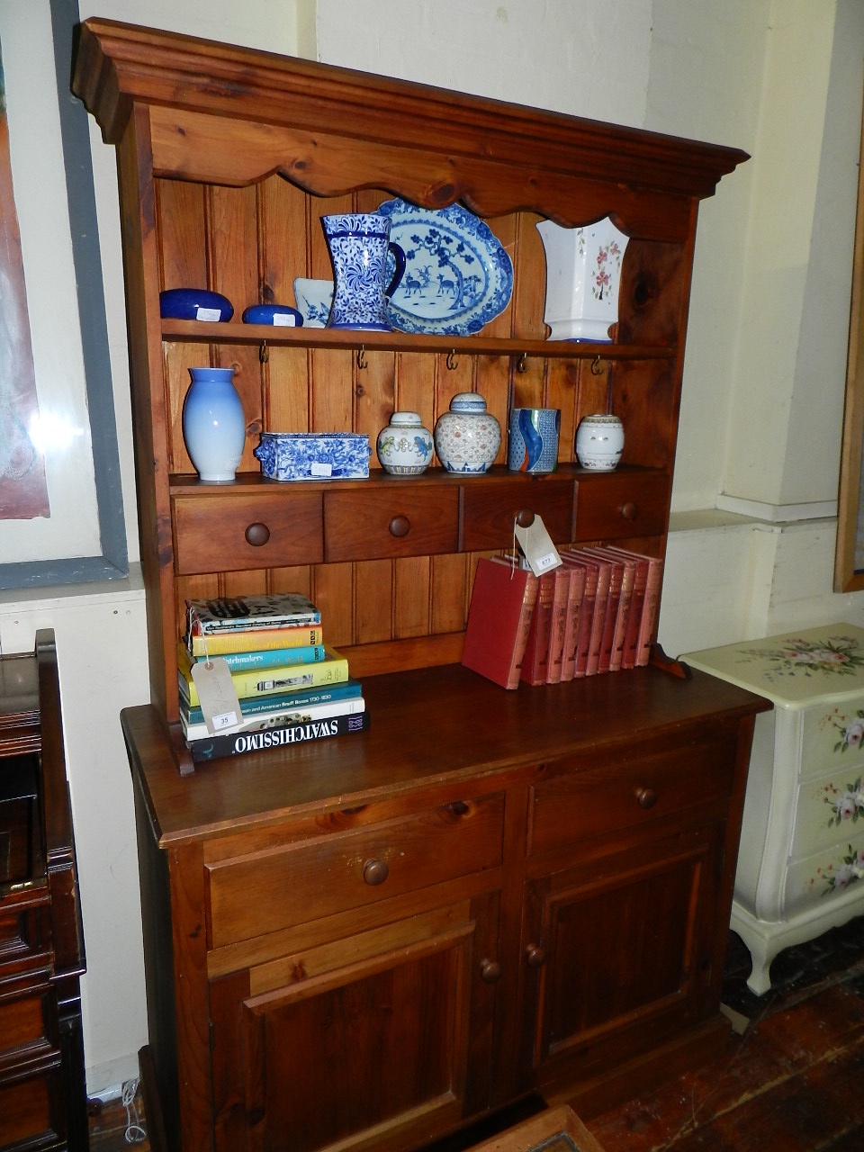 A stained pine dresser having superstructure plate rack with four drawers raised on a base of two