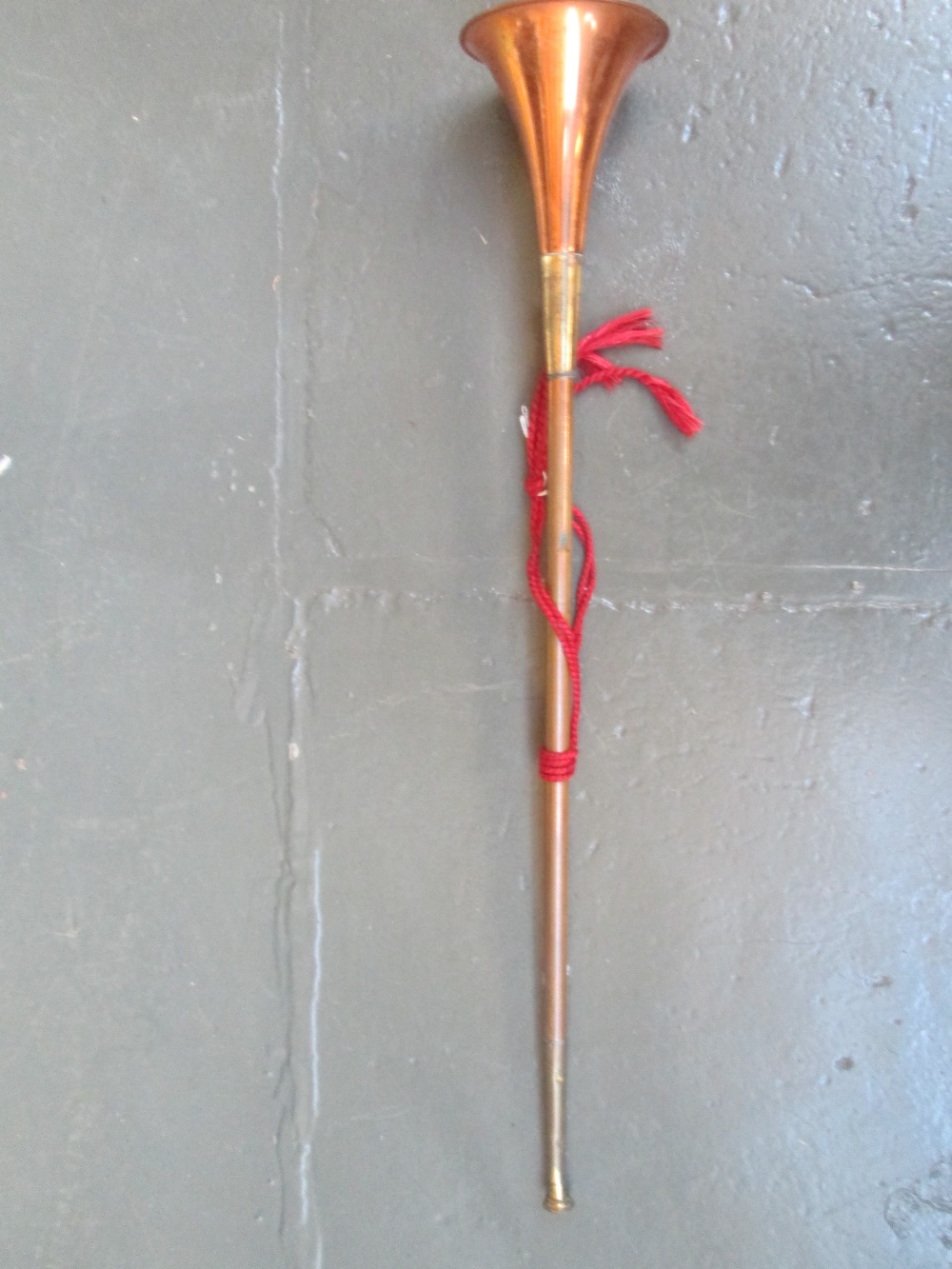 A 19th century copper and brass coaching horn, with red tassel, 75cm