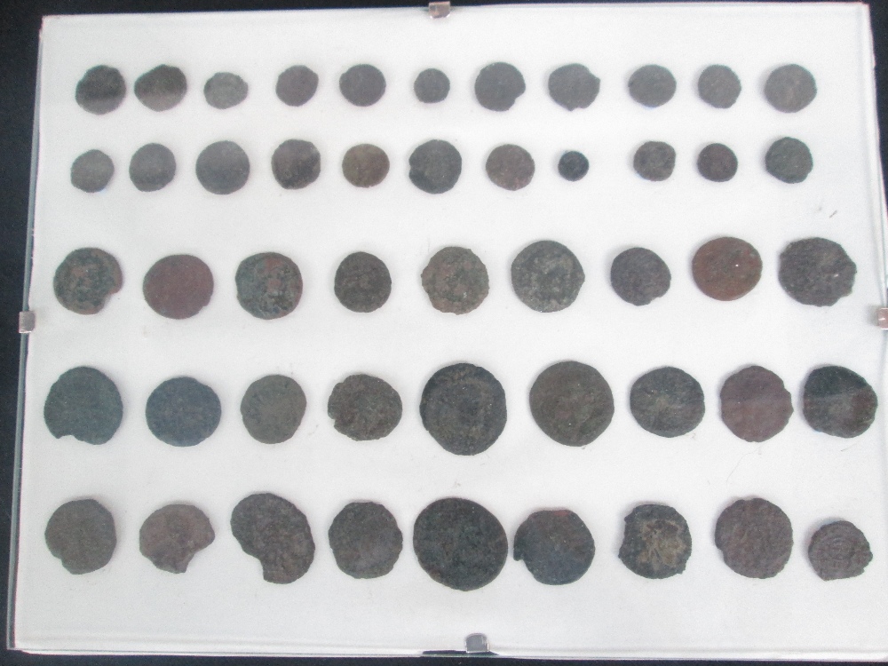 A framed collection of bronze Roman coins, mainly Denarius