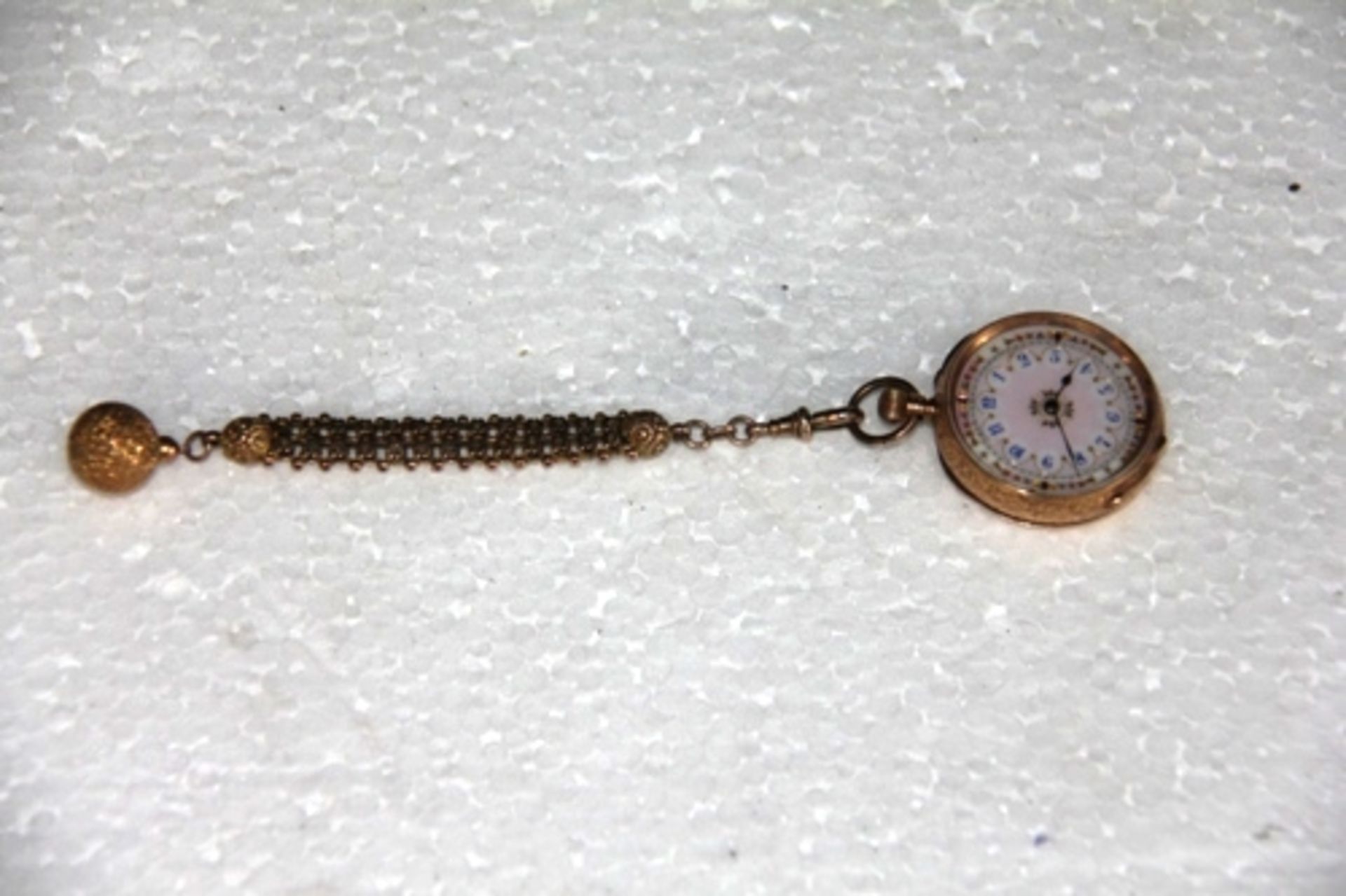 An engraved gold cased fob watch (stamped 14ct) with small intricate gold chain and ball end in