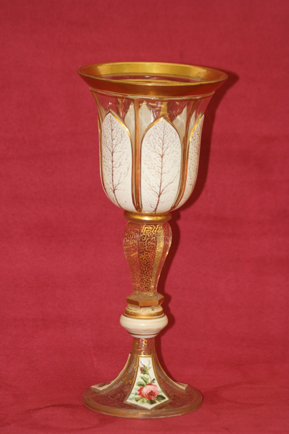 A Victorian overlaid glass goblet, decorated with foliate sprays heightened in gilt, on a baluster - Image 2 of 2