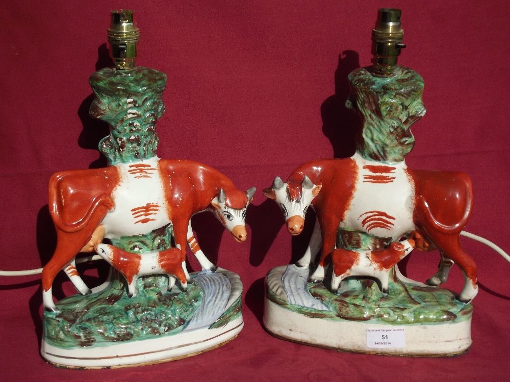 A pair of Staffordshire cow and calf groups, later converted to table lamps, 33cm high overall
