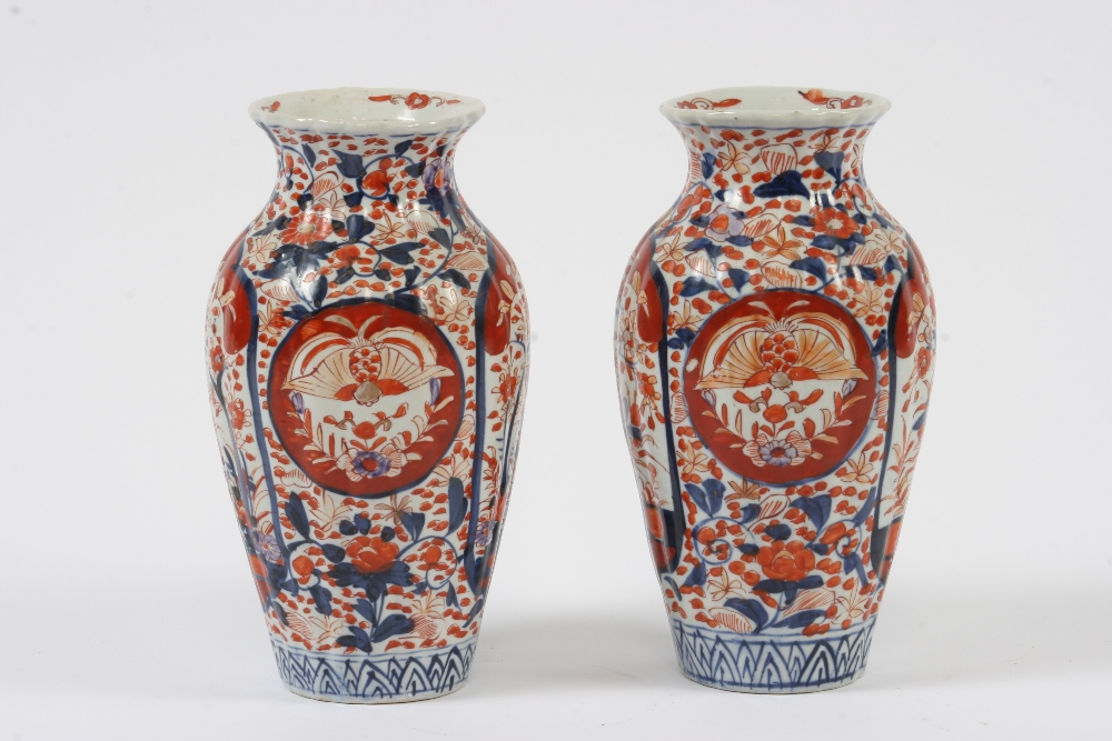 A pair of Japanese Imari baluster vases, decorated in the traditional manner with panels of