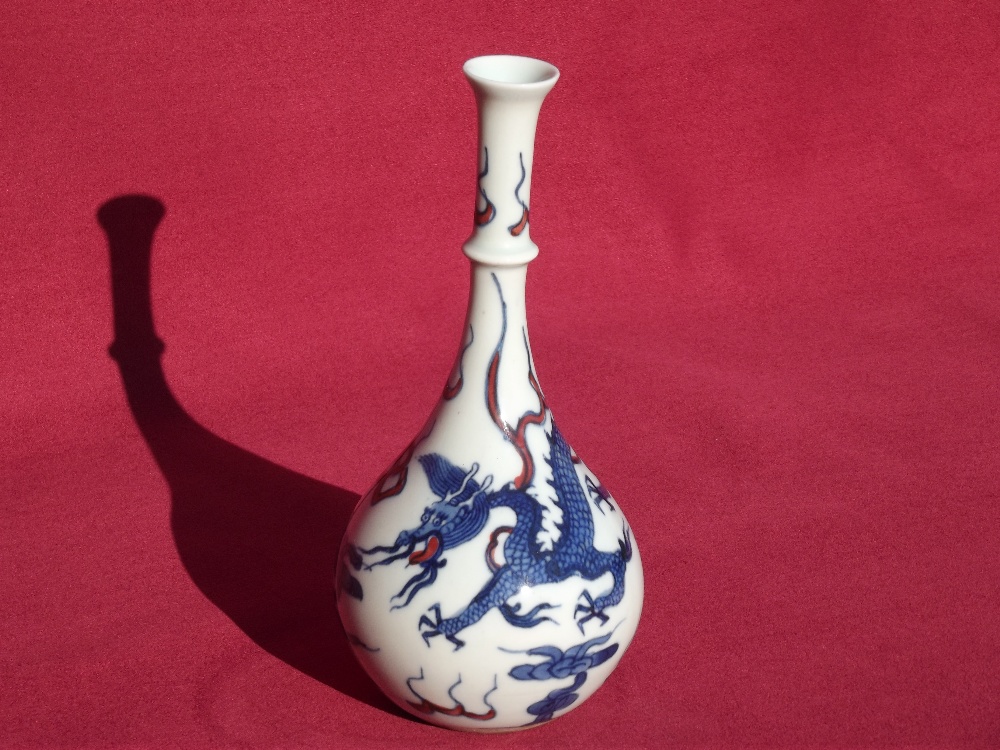 A Chinese bottle vase, of small proportions, decorated with dragons and clouds, leaf mark to the