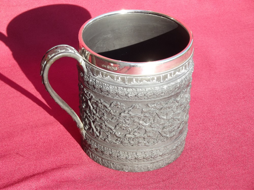 A Wedgwood Basalt mug, having raised oak leaf decoration and silver band, hallmarked for London