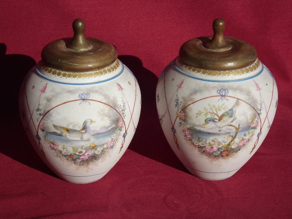 A pair of George Jones Bisque ware baluster pots, with wooden lids, having duck decoration, 15cm