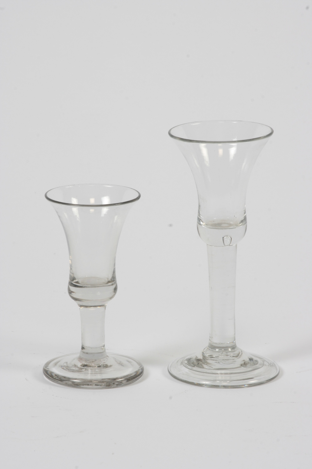 A Georgian wine glass, having bell shaped bowl and spread foot, 16.5cm high; and a smaller