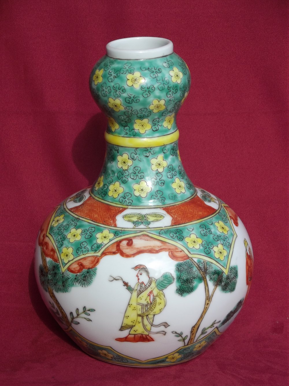 A Kang Hsi style bottle vase, decorated with figures and prunus, 26cm high