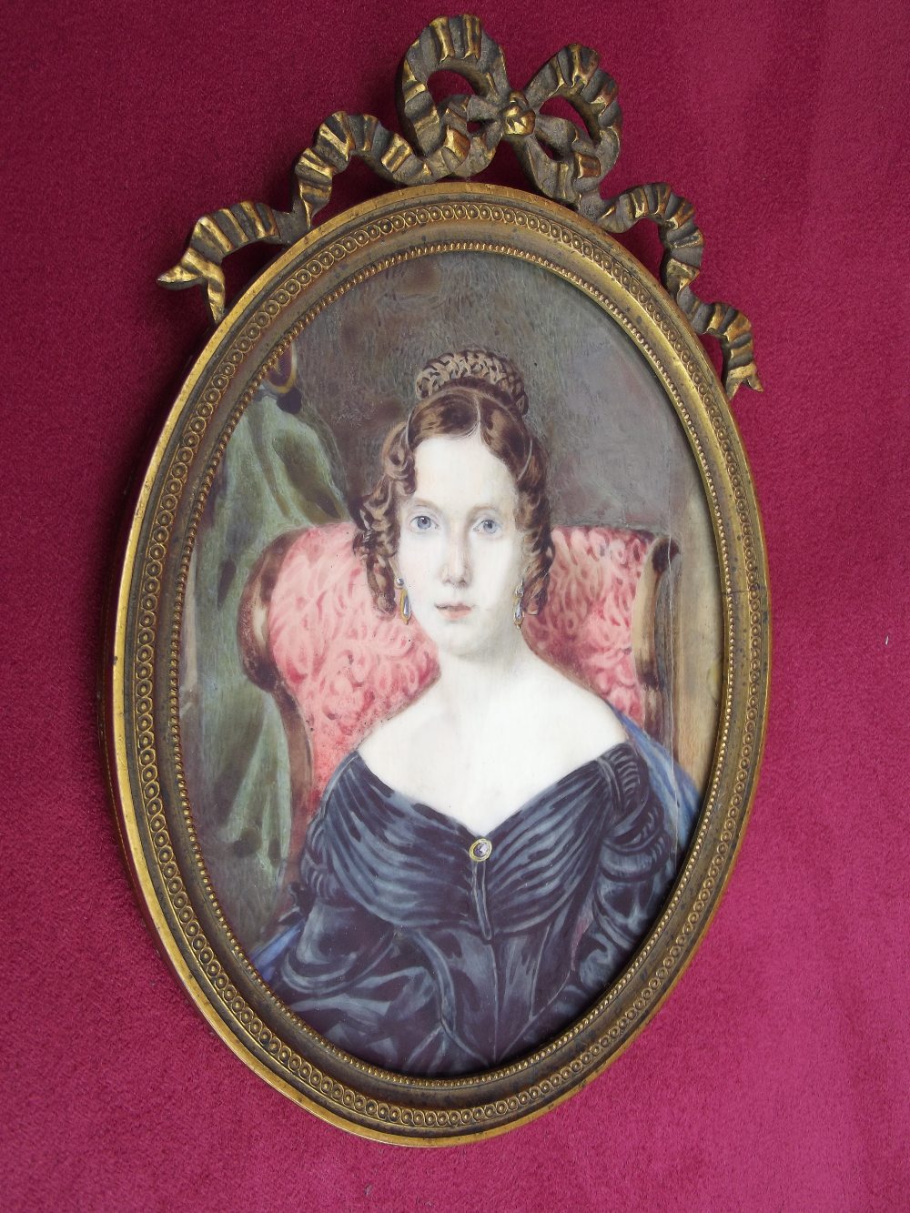 A 19th Century miniature portrait, of a seated lady in blue dress, contained in a gilt metal