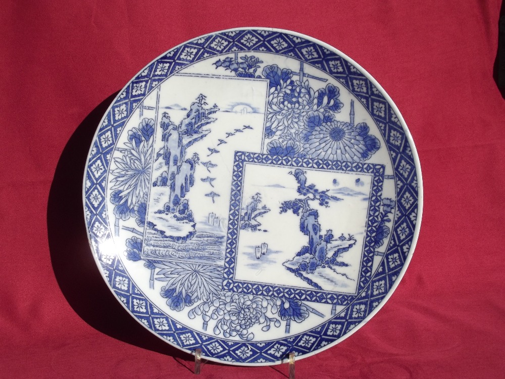 A 19th Century blue and white Japanese charger, decorated with scenes of birds, foliage and rockwork