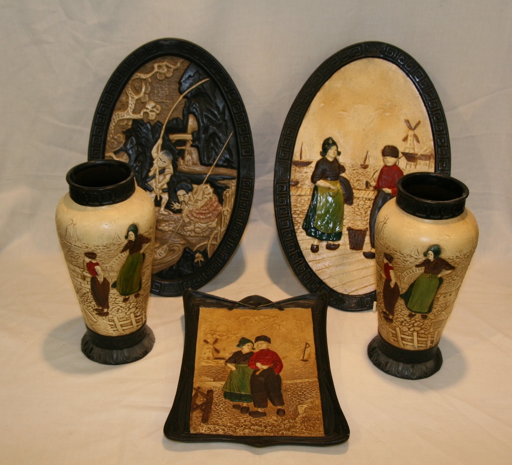 A pair of Bretby pottery vases, decorated with Dutch figures, 25.5cm; a Bretby oval plaque decorated