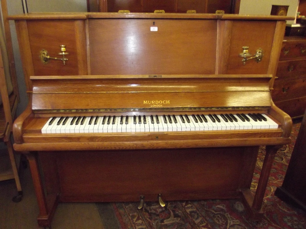 A Murdoch of London oak cased upright piano, fitted with brass candle sconces, 127cm x 150cm