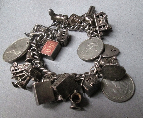 A silver curb link bracelet, hung with charms and coins [total approximate weight 4.55oz]