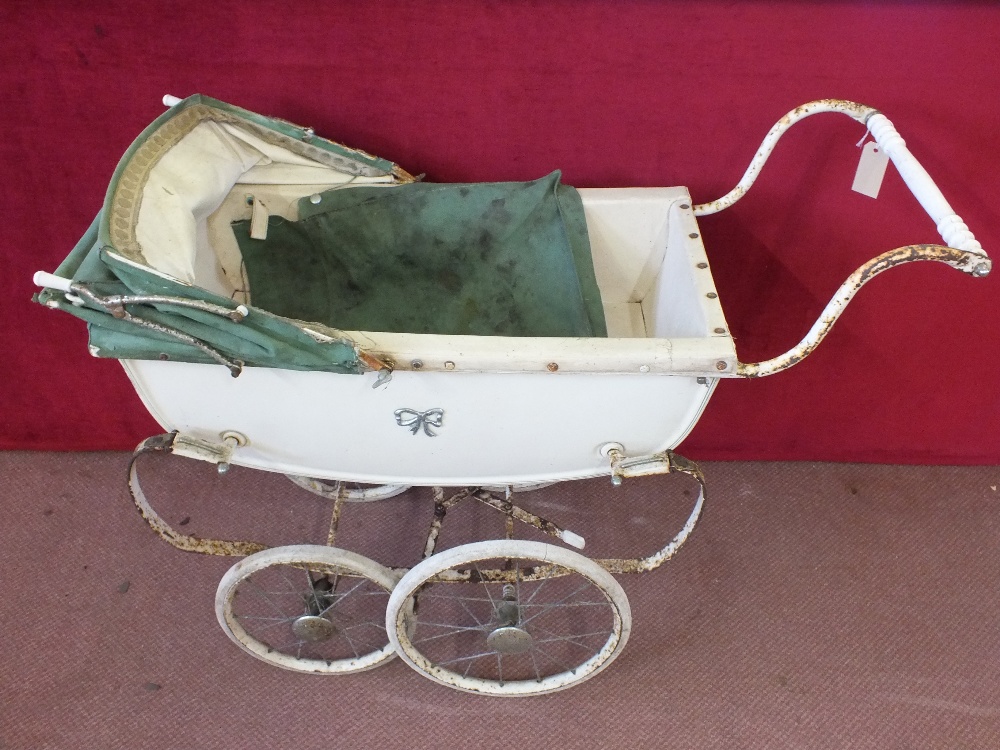 A Silver Cross dolls pram with forest green hood and cover