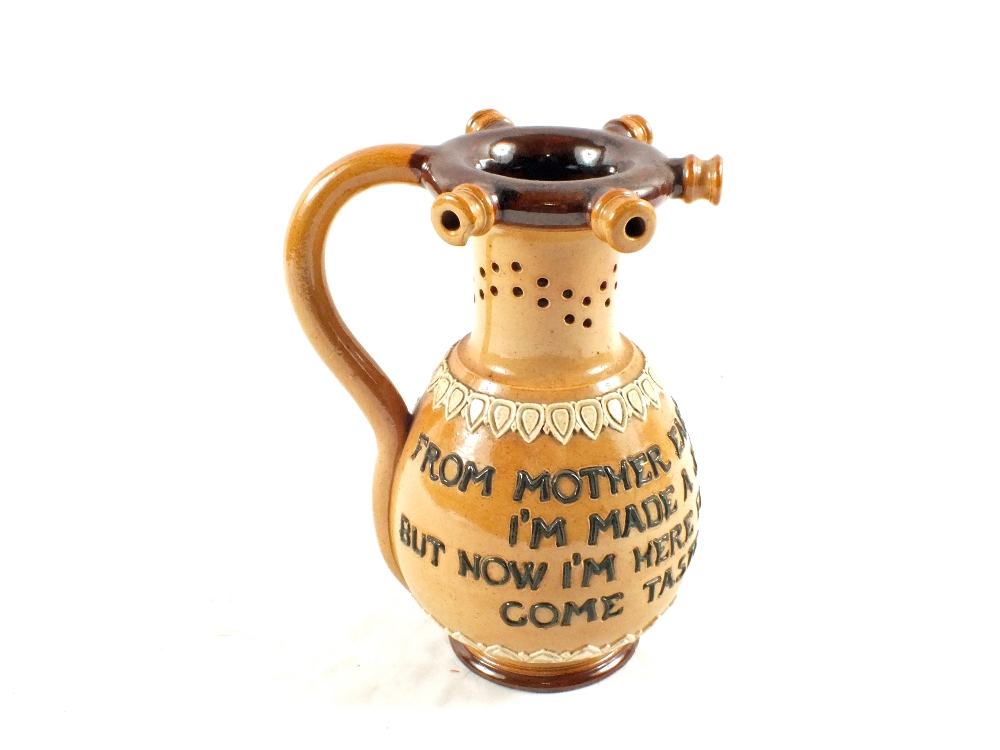 A Doulton Lambeth stoneware puzzle jug with motto inscription, height 7"