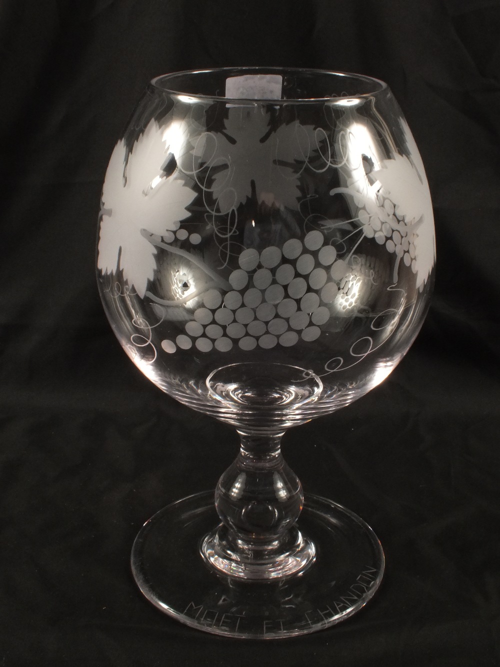 A large Moet & Chandon brandy glass with etched vine leaf decoration, height 13"