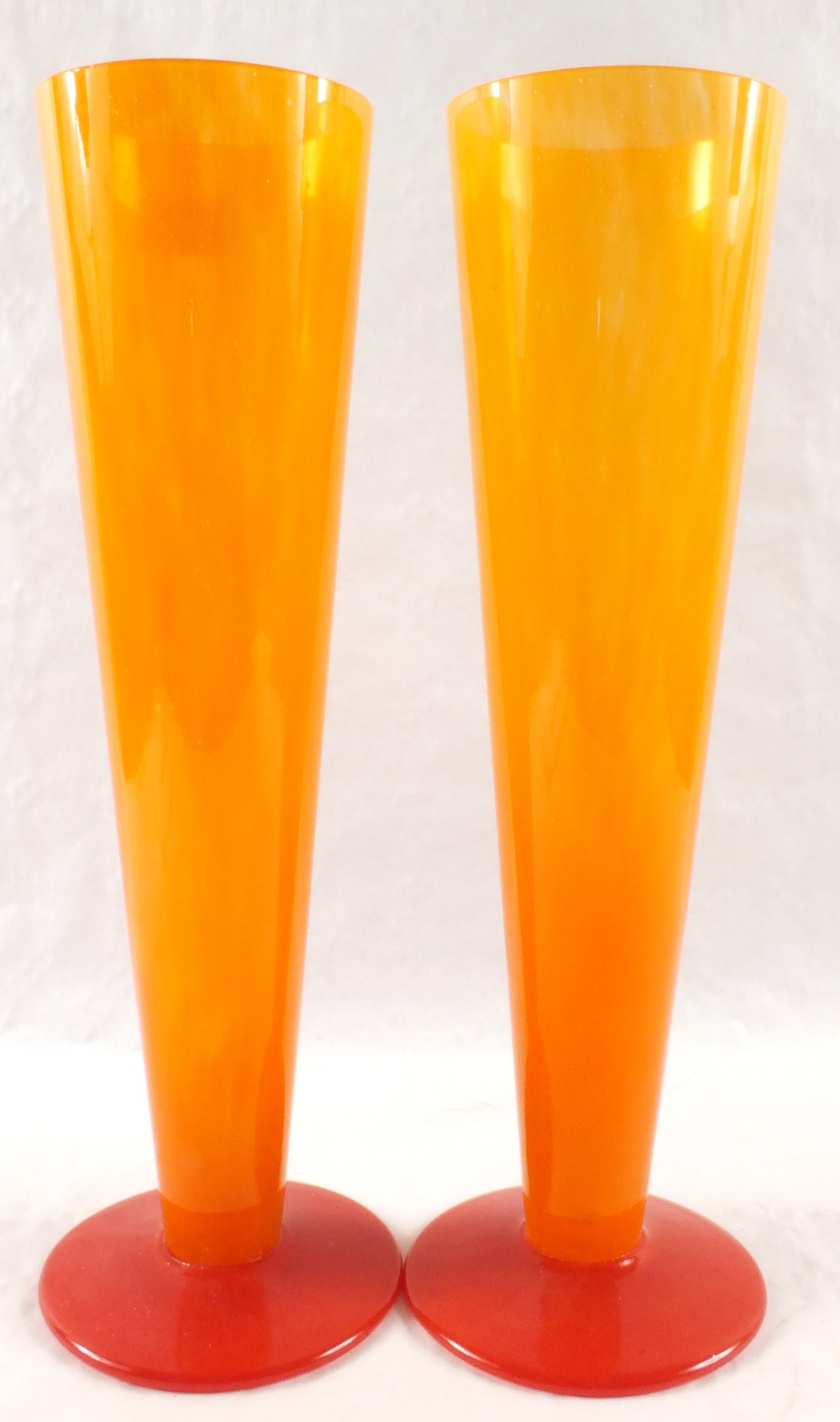 A pair of orange and red glass conical vases