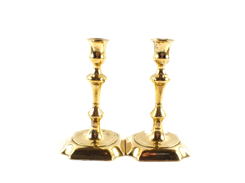 A pair of 18th Century seamed Brass candlesticks with baluster columns and square bases having