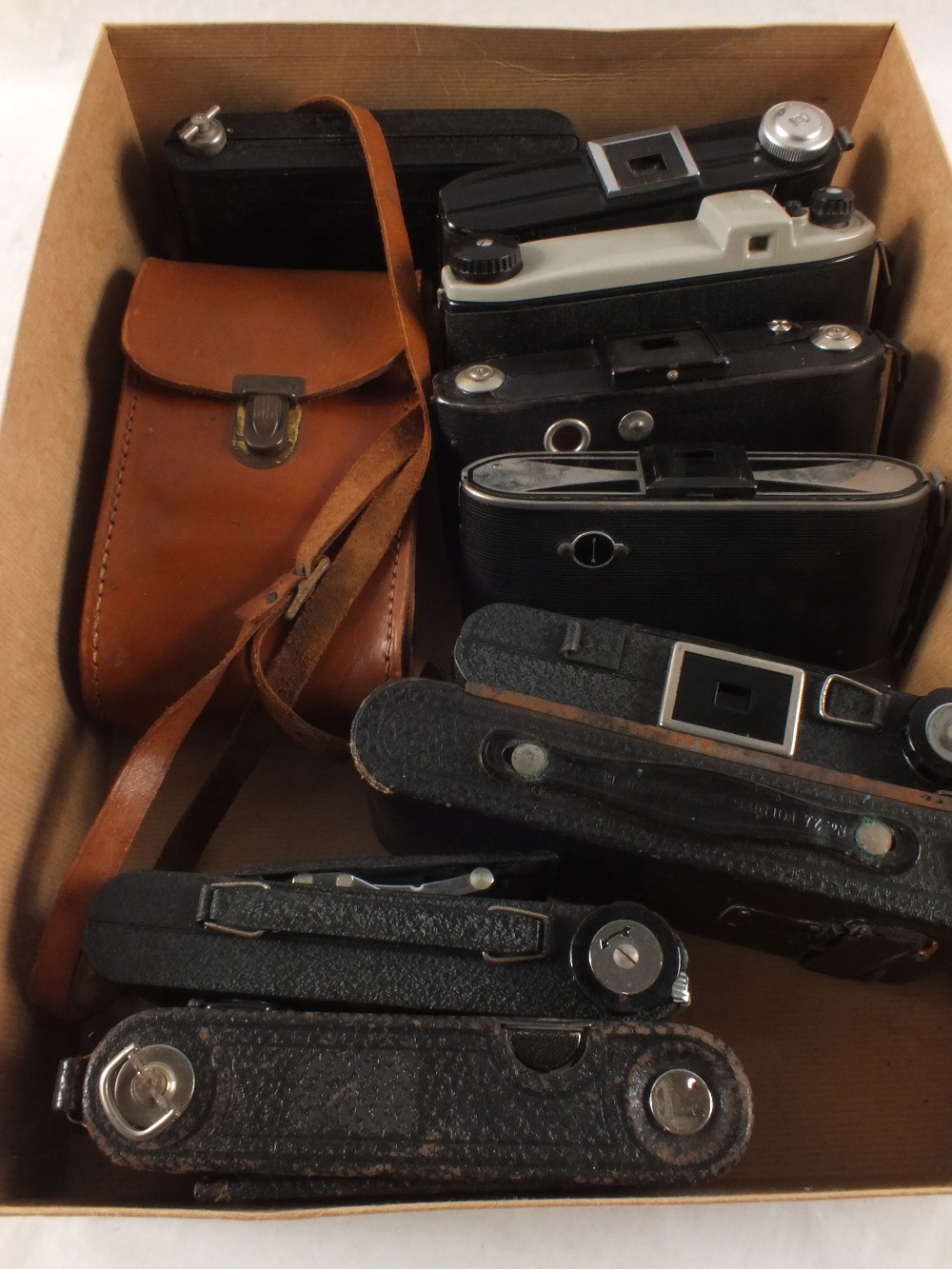 A box of various folding cameras